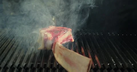 Close-up steak grilling on BBQ grid. Roasting tomahawk steak on barbecue grill Stock Footage 274584503
