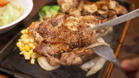 Close up steak knife cuts a slice from cooked sirloin steak as fork lifts s.. Stock Footage 229484798