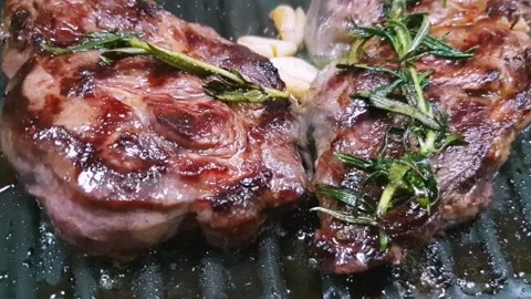 Close-up of steaks of marbled beef on the grill. Rosemary and garlic Video stock 130187666