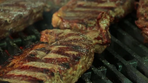 Close up of steaks smoking on a bbq grill Stock Footage 127715426