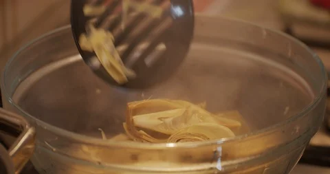 Close up of Steam and condensation while Drain artichokes from the Boiling Wa Stock Footage 128952541