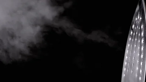 Close-up Steam Iron Blowing a Stream of Thick Steam on a Black Background Video stock 229465847