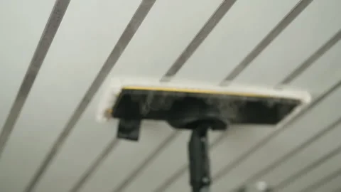 Close-up of steam mop cleaning white ceiling with parallel decorative strips Stock-Footage 319777302