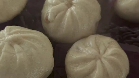 Close-up of steamed dumplings on red cabbage leaf with rising steam, macro food Stock Footage 333640452
