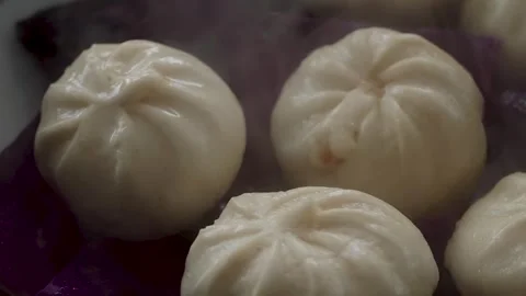 Close-up of steamed dumplings on red cabbage leaf with rising steam, macro food Stock Footage 333642428