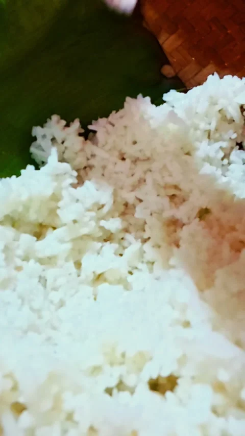 Close-up of steamed white rice served on green banana leaf Stock Footage 346740986