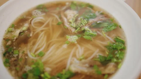 Close up of steaming beef noodle soup with herbs and broth in a restaurant meal 库存影片 345080453