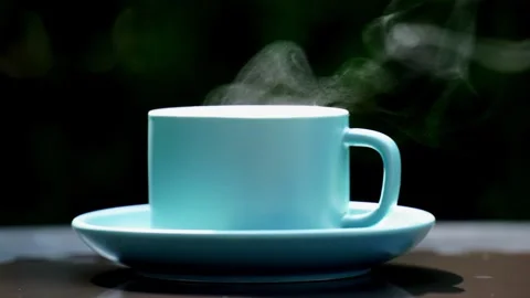 Close-up steaming hot coffee, Hot ceramic white coffee cup  Stockbeeldmateriaal 253536349