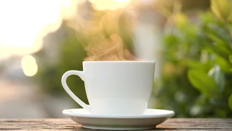 Close-up steaming hot coffee or tea cup on saucer, slow motion. Stock-Footage 143275039