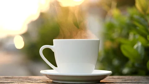 Close-up steaming hot coffee or tea cup on saucer, slow motion. Stock-Footage 143275612