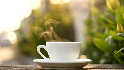 Close-up steaming hot coffee or tea cup on saucer, slow motion. Stock-Footage 143278771