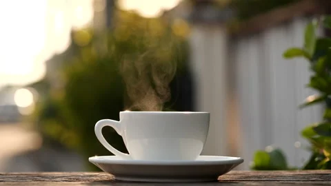 Close-up steaming hot coffee or tea cup on saucer, slow motion. Stock-Footage 143294812