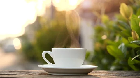 Close-up steaming hot coffee or tea cup on saucer, slow motion. Stock-Footage 143295329