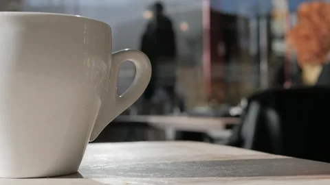 Close-up steaming hot tea or coffeein in white mug on a table in a cafe, close Stock Footage 305746556