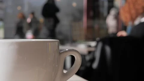 Close-up steaming hot tea or coffeein in white mug on a table in a cafe, close Stock Footage 305746583