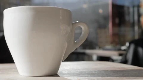 Close-up steaming hot tea or coffeein in white mug on a table in a cafe, close Stock Footage 305747207