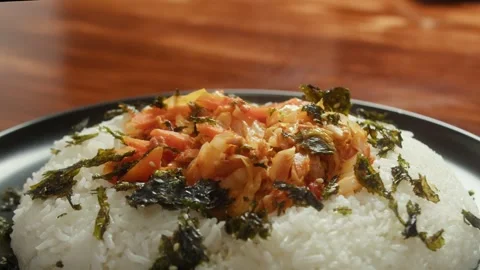 Close up of steaming white rice topped with kimchi and roasted seaweed on a Stock Footage 339918409