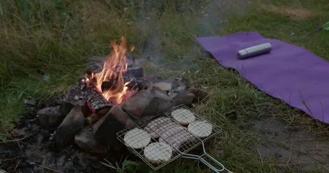 Close up of steel grid withbread rolls lying near fire Stock Footage 158744271