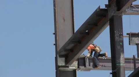 Close up of steel workers laying a beam while strapped in to the beam line vi Stock Footage