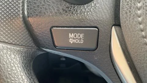 Close?up of steering wheel mode button showing hold function label Stock Photos