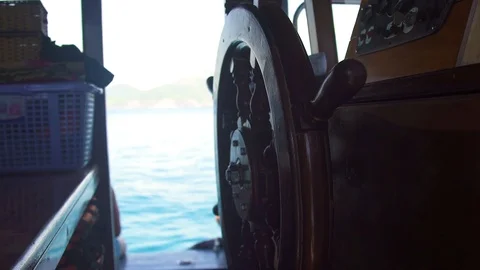 Close up steering wheel of sailing ship in captain bridge on blue sea landscape Stock Footage 95876851