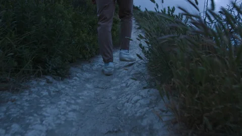 Close up steps of young man backpacker traveler is slowly walking alone along a Video stock 166049435