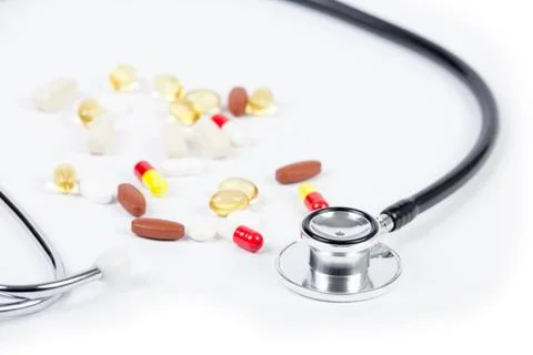 Close up of stethoscope a pills on table Stock Photos