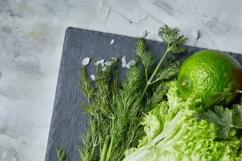 Close-up still life of assorted fresh vegetables and herbs on white textured Photos