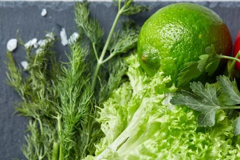 Close-up still life of assorted fresh vegetables and herbs on white textured Photos