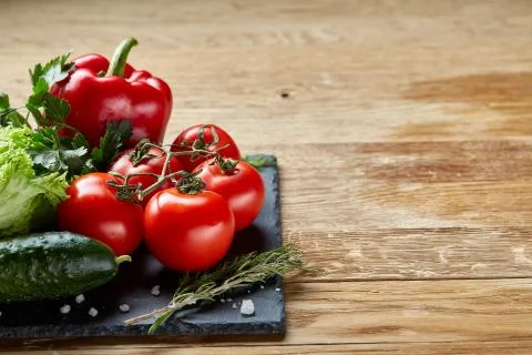 Close-up still life of assorted fresh vegetables and herbs on wooden rustic Stock Photos