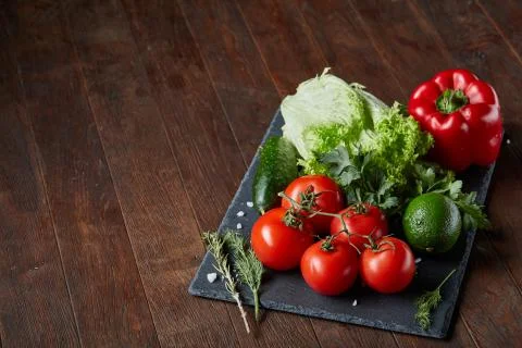 Close-up still life of assorted fresh vegetables and herbs on wooden rustic Stock Photos