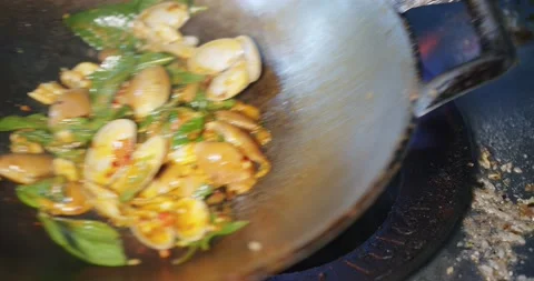 Close up Stir Fried Clams with Roasted Chili paste and basil in hot frying pan a Stock Footage 145921337