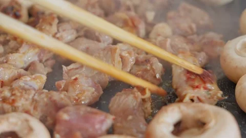Close-up of stir-fried mutton cubes and white mushrooms on iron plate with Stock Footage 341650000