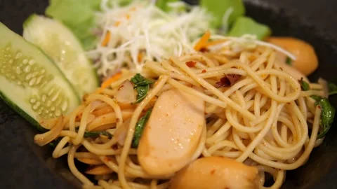 Close-up of stir-fried spicy spaghetti with sausage, dried chili, and basil Video stock 332144717
