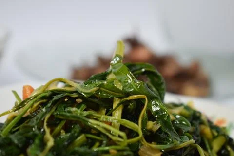 Close-up stir-fried spinach on white plate isolated white background Stock Photos
