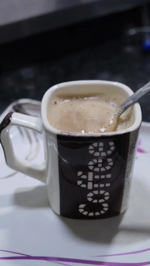 Close up of stirring hot coffee with a spoon in a ceramic mug Stock Footage 331004271