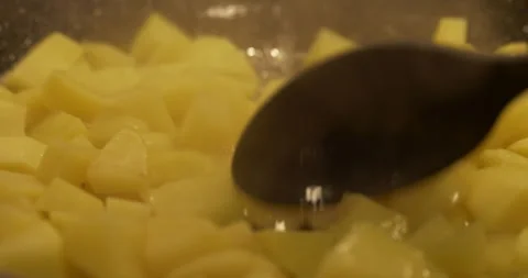 Close-up stirring potatoes while frying 5.7K video Stock Footage 301768225