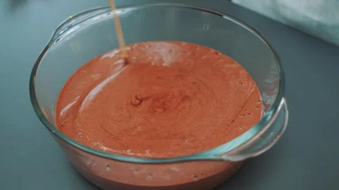 Close-up of stirring reddish-brown batter with wooden skewer in kitchen Видео 342885150
