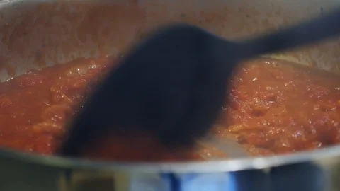 Close up stirring tomato base sauce in saucepan with black spoon Stock Footage 111891817