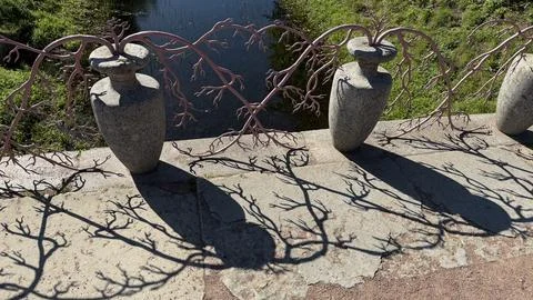 Close-up of a stone bridge parapet featuring decorative stone vases and an iron 库存照片