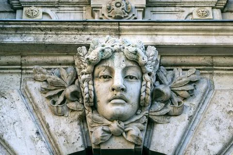 Close-up of a stone human face as decor or Mascaron on building facade Stock Photos