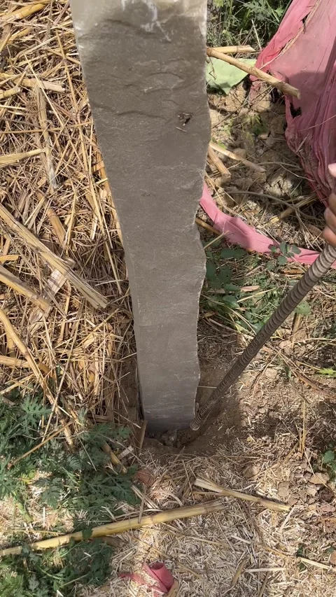 Close up of stone pillar being installed in ground for fencing Stock Footage 331774857