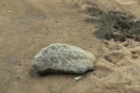 Close up of a stone on a sandy beach Stock Photos