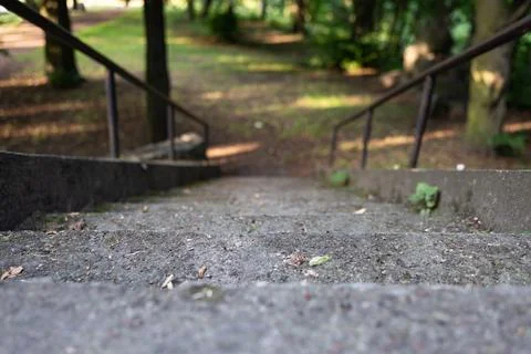 Close up of stone stairs surrounded by two metal handrails Foto stock