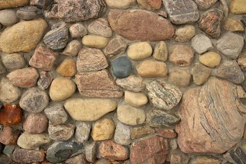 Close up of A stone Wall Built with Multi Colored Rocks and Cement Mortar Stock Photos