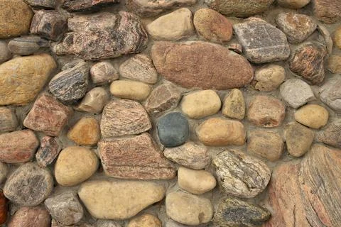 Close up of A stone Wall Built with Multi Colored Rocks and Cement Mortar Stock Photos