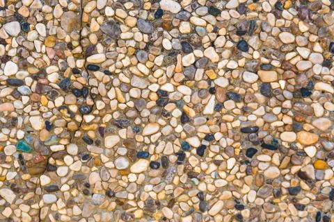 Close-up of stone wall with different pebbles. Stock Photos