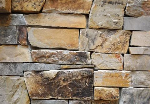 Close up of a stone wall texture. yellow and brown Stock Photos