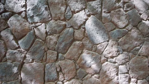 A close-up of a stone wall with textured rock surfaces, highlighted by sunl.. Stock Footage 285882926