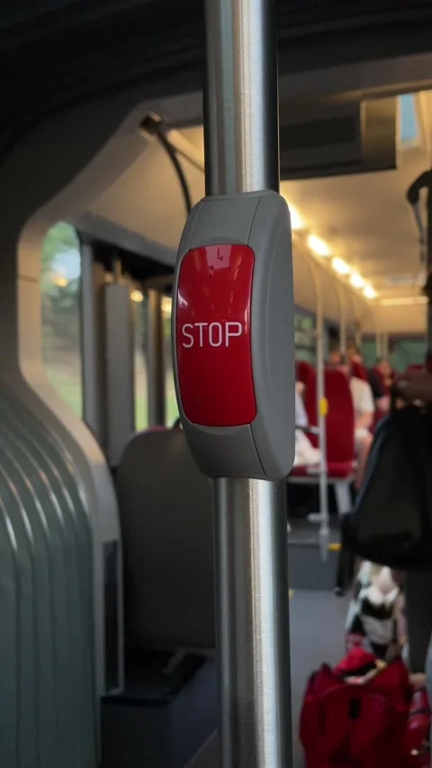 Close-up stop request button on stainless pole inside public bus interior at Stock Footage 341663065